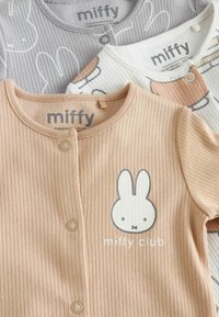 Tri majice za djecu od mekanog rebrastog materijala. Boje uključuju bež, sivu i bijelu, s ilustracijama zečića i tekstom "miffy club".