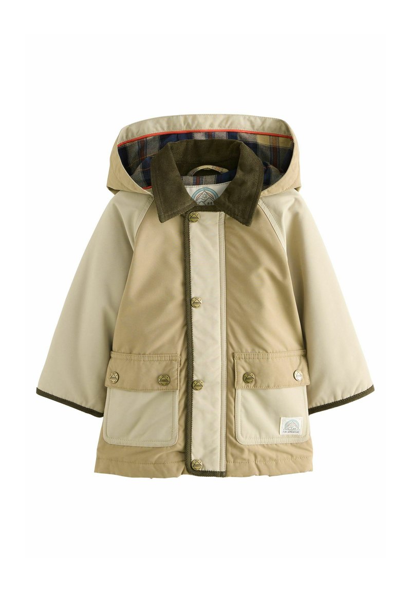 Giacca impermeabile beige e crema con cappuccio, caratterizzata da un colletto in corduroy marrone, foderata a scacchi e dotata di due tasche frontali con chiusura a bottone.