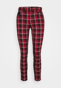 Pantalons slim fit avec un motif à carreaux rouge, noir et blanc, bouton à l'avant et poches sur fond blanc.