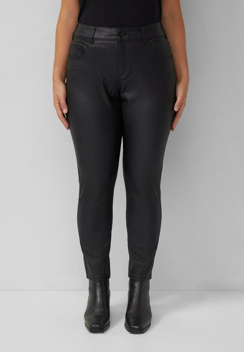 Must mustrõngast nahast püksid, millel on slim fit, viie taskuga disain ja pahkluuni ulatuv lõige, koos mustade kontsakatega saapadega. Sile tekstuur.