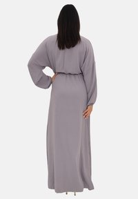 Robe grise ample et fluide en tissu doux, avec une taille cintrée et des manches larges, vue de dos.