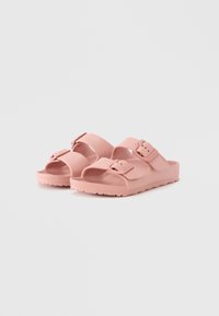 Rosa gummisandaler med to justerbare stropper og spenner. Kryssende overdel med åpen tå og teksturert såle for grep.