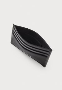 Portefeuille en cuir noir avec plusieurs emplacements pour cartes, texture lisse et design épuré, partiellement ouvert pour montrer la doublure intérieure.