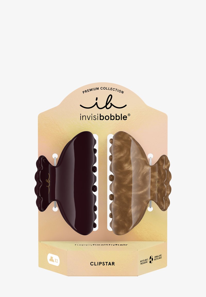 Deux grandes pinces à cheveux en brun foncé et beige marbré sur un emballage beige étiqueté « invisibobble Clipstar » et marqué recyclable.
