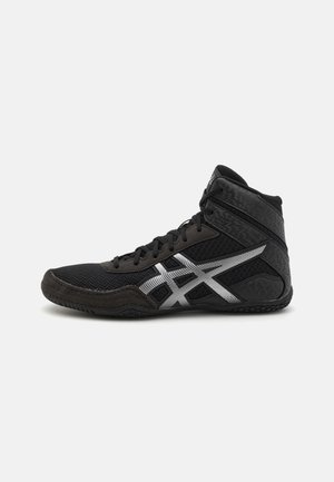 Černá vysoká sportovní bota s texturovaným svrškem, stříbrnými detaily a gumovou podrážkou pro vylepšenou trakci. Šněrování poskytuje podporu.