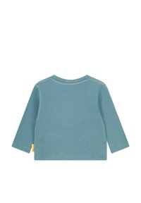 Langsleeve shirt in zachte teal katoen. Heeft een ronde halslijn, eenvoudige stikdetails en een klein geel label aan de zoom.