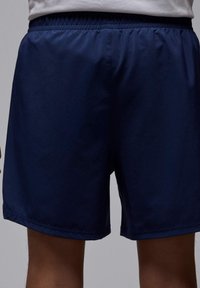 Mørkeblå shorts lavet af et letvægtsstof; elastisk talje med ingen synlig hardware; knælængde, glat tekstur, minimalistisk design.