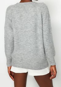 Grauer, gestrickter Pullover mit einem gerippten Textur, Rundhalsausschnitt und langen Ärmeln. Verfügt über Schulterdetails und einen lässigen Schnitt.