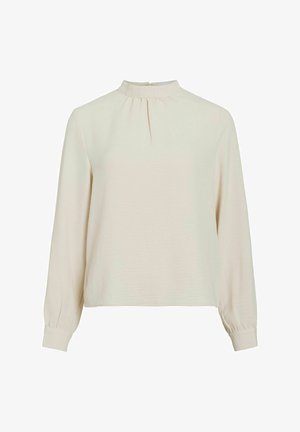 Blouse beige clair à manches longues avec un col montant, une finition froncée au niveau du col et des poignets élastiqués. Texture lisse et design minimaliste.