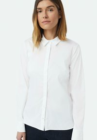 Weißes Hemd mit klassischem Kragen, langen Ärmeln und geradem Saum. Hergestellt aus glattem Stoff, minimalistisches Design, keine sichtbaren Muster oder Akzente.