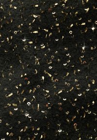 Tissu noir texturé parsemé de petites paillettes dorées brillantes et de morceaux de paillettes reflétant la lumière.