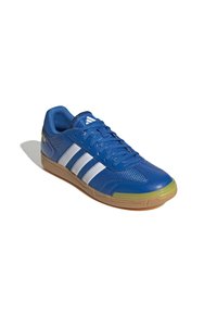 Baskets de sport bleues avec tige en synthétique, rayures blanches, panneaux en maille texturée, col rembourré et semelle en caoutchouc gomme avec composé anti-dérapant.