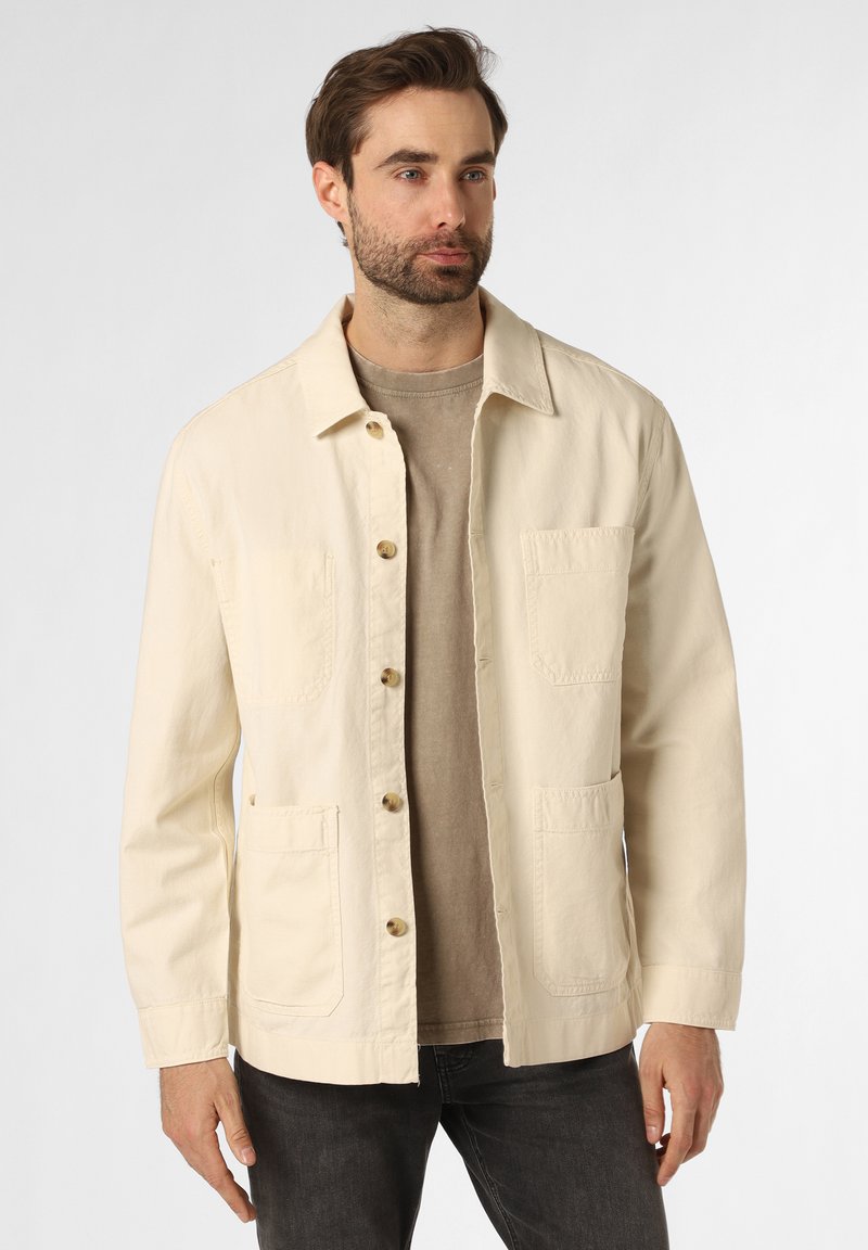 Chaqueta de algodón beige claro con cuello de solapa, cierre frontal de botones, dos bolsillos en el pecho y mangas largas. Textura sutil y ajuste relajado.