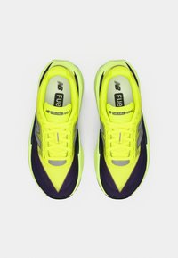 Φωσφορίζον κίτρινο παπούτσι τρεξίματος με μαύρες λεπτομέρειες, υλικό από δίχτυ και αεροδυναμικό σχεδιασμό. Διαθέτει μαξιλαρωμένη σόλα και ανακλαστικό λογότυπο.