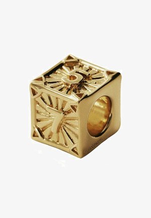 Charm de metal dorado en forma de cubo. Presenta números en relieve '5' y '7', con intrincados patrones de rayos de sol y un centro hueco.