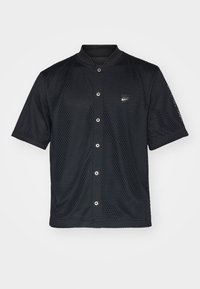 Maglietta nera a maniche corte in rete con colletto, chiusura a bottoni e logo Nike. Tessuto testurizzato con un design traspirante.