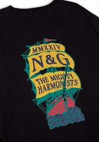 Camiseta negra con un gráfico colorido de un barco con pancartas que muestran "MMXXIV", "N&G" y "THE MIGHTY HARMONISTS" en amarillo y azul.