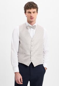 Hellgrau gemusterte Weste mit V-Ausschnitt, fünf Knöpfen und zwei Seitentaschen, kombiniert mit einer passenden Fliege über einem weißen Hemd.