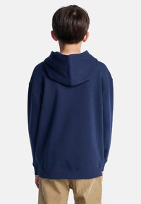 Sudadera con capucha de color azul marino, con un corte relajado y dobladillo acanalado, que ofrece un diseño clásico de capucha y un tejido suave y texturado.
