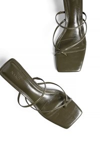 Olivgröna högklackade sandaler med glänsande yta, fyrkantig tå och sammanflätade ankelremmar. Texturerad ovandel, elegant och minimalistisk design.