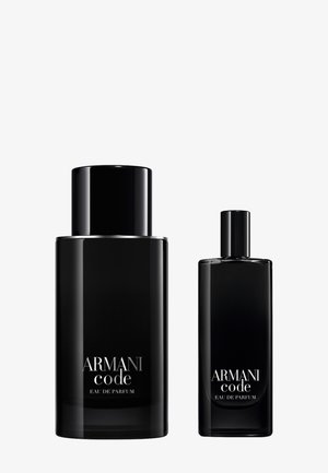 Bottiglie di profumo in vetro nero, una alta con una forma cilindrica e l'altra più corta, entrambe etichettate "Armani Code Eau de Parfum."