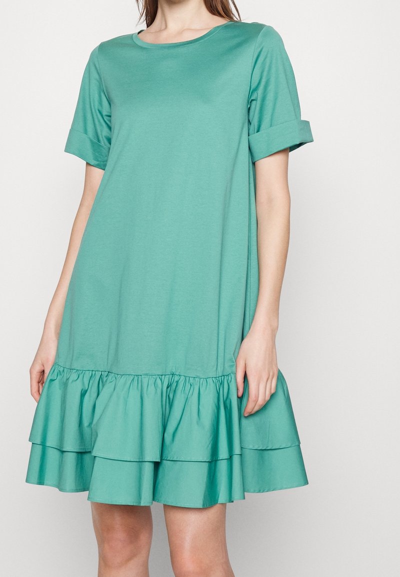 Robe bleue-vert à manches courtes avec un décolleté arrondi et un ourlet à volants superposés. Fabriquée en matériau doux, elle présente une coupe décontractée et des poignets à revers.