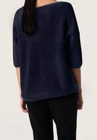 Marineblauer Strickpullover mit lockerer Passform, weitem Bootsausschnitt und dreiviertellangen Ärmeln. Weiche Textur, leicht ausgefranster Saum.