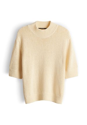 Pull tricot à manches courtes de couleur crème avec un col rond côtelé épais et des poignets et un ourlet côtelés, présenté sur un fond blanc.