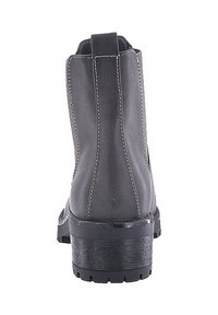 Botas de cuero negro hasta el tobillo con una textura suave, costuras laterales y una suela resistente y texturizada. Presenta un tacón bajo y grueso para mayor estabilidad.