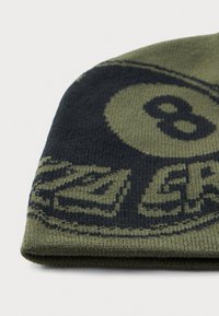 Groene en zwarte gebreide beanie met een groot nummer 8 en gedeeltelijk omringende geometrische patronen.