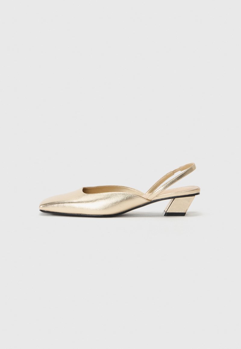 Slingback con tacco in metallo dorato, a punta, con tacco basso e texture liscia. Design minimalista con dettaglio di taglio laterale.