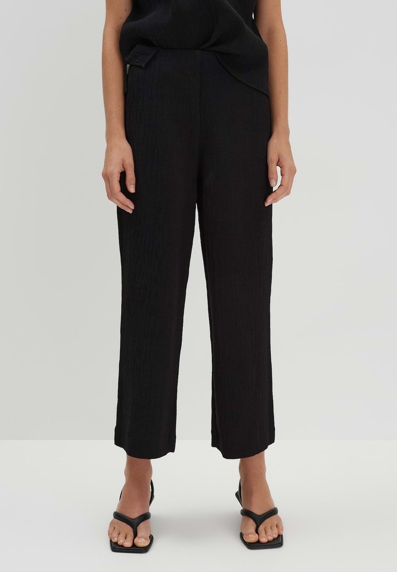 Zwarte, gestructureerde wijde broeken met een hoge taille, voorzien van een subtiel geplisseerd ontwerp en een rechte snit die halverwege de enkel eindigt.