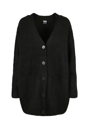 Mustast üle suurusega kampsunist kardigan V-kaelusega, viie ees oleva nupu, kahe ees oleva tasku ja pikkade varrukatega.