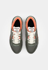 Šedé tenisky s b�ílými tkaničkami a oranžovými akcenty. Mají texturovaný svršek, polstrovaný límec a logo Reebok na jazyku.