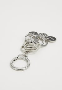 Metal keychain featuring interlocking rings in polished silver, and three tags: black with white text "CAT" and "HOME" and a circular logo accent.