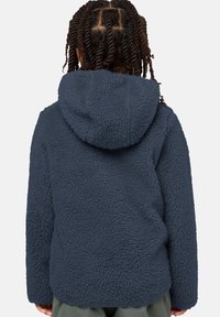 Marineblaue Fleecejacke mit einer strukturierten, plüschigen Oberfläche, ausgestattet mit einer Kapuze und langen Ärmeln, entworfen für Wärme und Komfort.