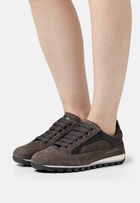Zapatillas de ante gris con detalles de cuero negro, con punta redonda, diseño de cordones y suela de goma texturizada para agarre y durabilidad.