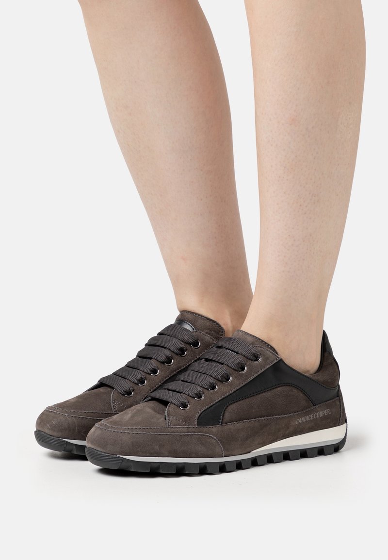 Zapatillas de ante gris con detalles de cuero negro, con punta redonda, diseño de cordones y suela de goma texturizada para agarre y durabilidad.