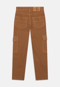 Pantalones cargo marrones hechos de un tejido resistente, con múltiples bolsillos, un diseño de pierna recta, costuras cosidas y un parche con el logo en la cintura.