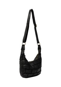 Borsa a spalla in pelle nera con design a patchwork, zip dorata e tracolla regolabile appesa su uno sfondo bianco.
