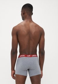 Szürke pamut boxer sín, piros Levi's logós derékpánttal, testhezálló fazonnal és sima textúrával. Hátsó nézet.