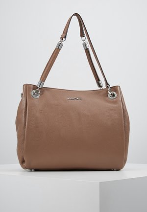 Sac à main en cuir texturé marron avec accessoires en argent et doubles anses d'épaule, posé sur une surface blanche devant un fond gris clair.