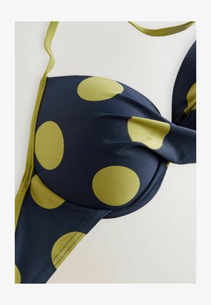 Marineblaue Bikini-Oberteil mit großen olivgrünen Pünktchen. Verfügt über glattes Material, ein gepolstertes Design und verstellbare Träger.