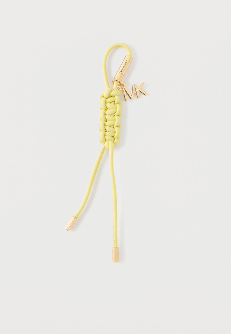 Porte-clés en cuir tressé jaune avec ferrures dorées et pendentif "MK" sur fond blanc.