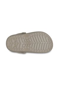 Beżowa gumowa podeszwa butów z teksturowaną, rowkowaną powierzchnią oraz okrągłymi wzorami bieżnika, z wytłoczonym napisem "crocs".
