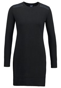 Robe noire à manches longues avec texture côtelée, encolure ronde et accents en simili cuir sur les épaules. Coupe slim, design jusqu'aux genoux.