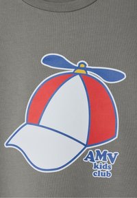 Hallide hallikas T-särk, millel on punase, valge ja sinise propelleriga mütsi graafika ning tekst "AMV laste klubi" sinises.