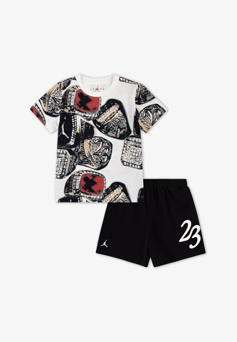 Kortærmet hvid T-shirt med ringgrafikprint og sorte shorts med "23" i hvid på siden og et logo på kanten.