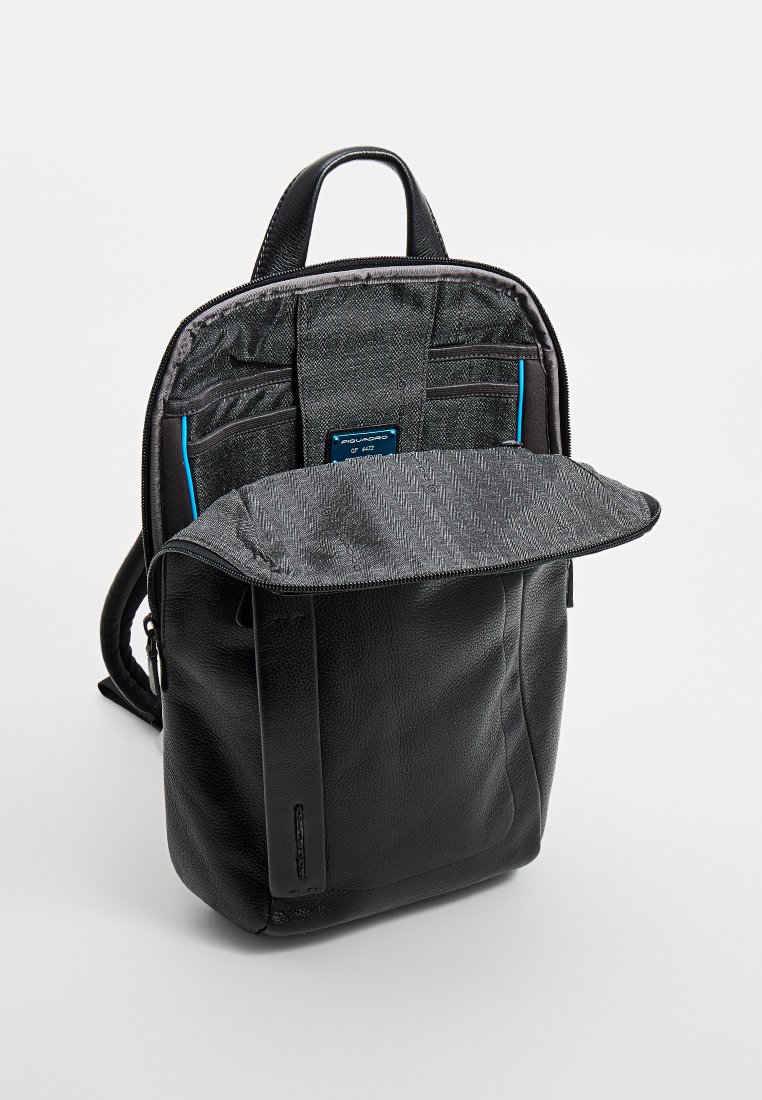 Zwarte rugzak met een gestructureerde afwerking, voorzien van een hoofcompartiment met rits en een voorvak, accentueert met een blauwe tag en grijs stoffen interieur.