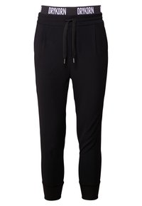 Czarne zwężane spodnie dresowe z elastycznym paskiem w talii, z białym napisem "DRYKORN", zapięciem na sznurki i ściągaczami na kostkach.
